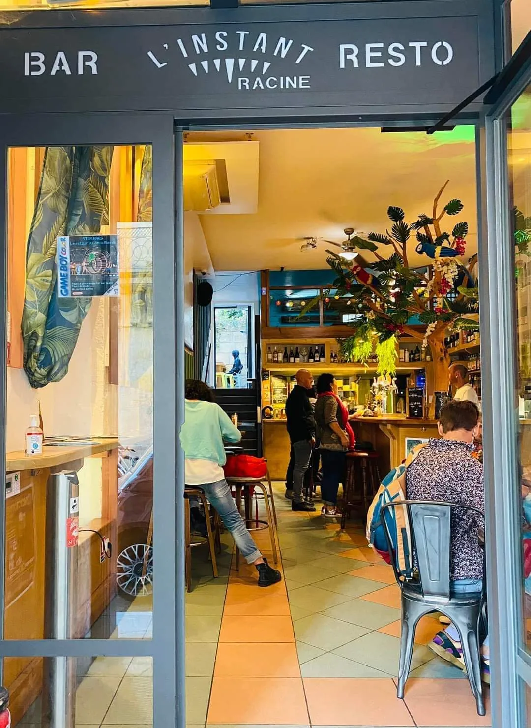 La devanture de L'Instant T rue Racine, enseigne « Bar, L'Instant T, Resto », porte ouverte sur la salle